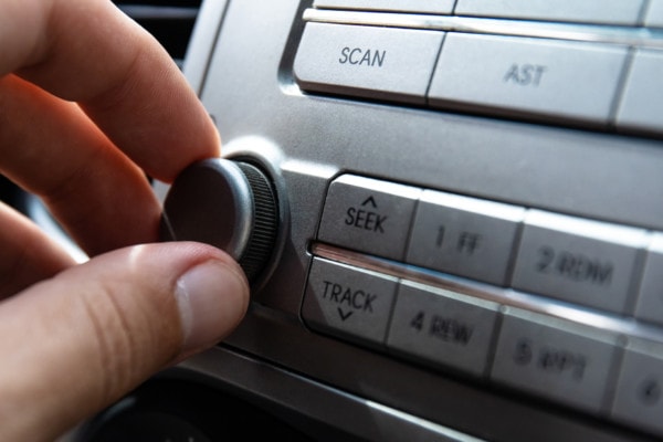 The Driver Turns The Volume Knob In The Car